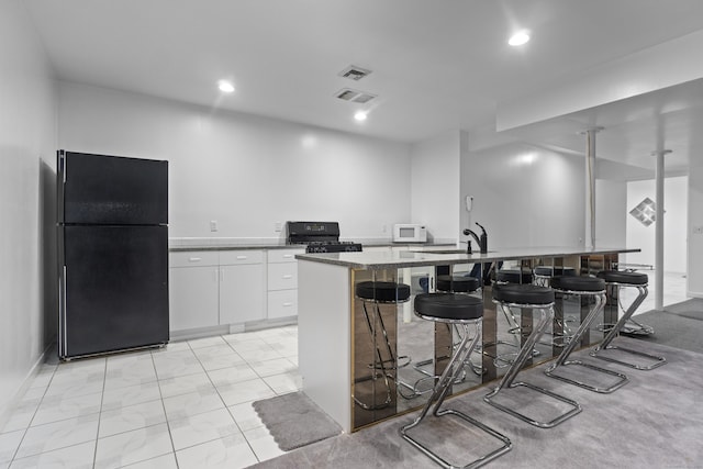 45 Brookview Ct, Groton, CT 06340 - kitchen featuring black appliances, a kitchen breakfast bar, white cabinetry, recessed lighting, and modern cabinets