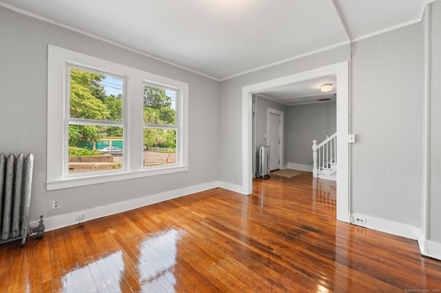 49 Freeman Ave, Norwich, CT 06360 - empty room with radiator, wood-type flooring, stairway, ornamental molding, and a decorative wall