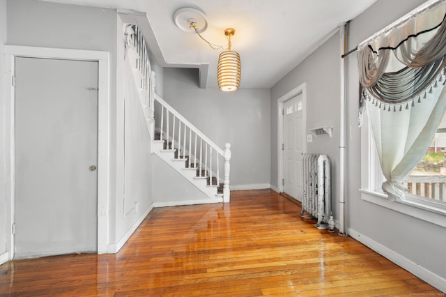 49 Freeman Ave, Norwich, CT 06360 - foyer entrance featuring radiator, stairs, and wood finished floors