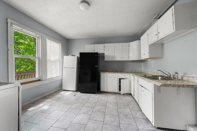 49 Freeman Ave, Norwich, CT 06360 - kitchen with freestanding refrigerator, stove, a textured ceiling, and white cabinetry