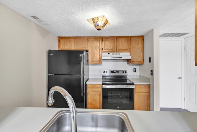 173 Russo Ave Unit 409, East Haven, CT 06513 - kitchen featuring freestanding refrigerator, stainless steel range with electric stovetop, under cabinet range hood, light countertops, and a textured ceiling