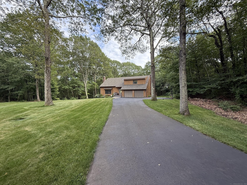 681 Willis St, Bristol, CT 06010 - view of front of home with driveway, a front lawn, an attached garage, and a chimney