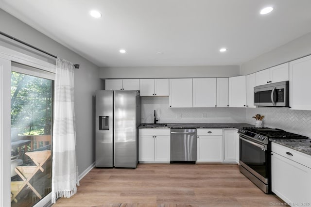 121 Russo Ave Unit 11, East Haven, CT 06513 - kitchen featuring appliances with stainless steel finishes, backsplash, white cabinetry, recessed lighting, and dark stone countertops