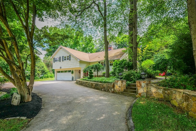 24 Buttonball Ln, Glastonbury, CT 06033 - view of front of home featuring a garage, asphalt driveway, and a chimney