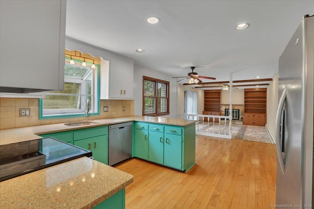 53 Montclair Dr, Manchester, CT 06042 - kitchen with appliances with stainless steel finishes, a peninsula, light countertops, green cabinetry, and recessed lighting