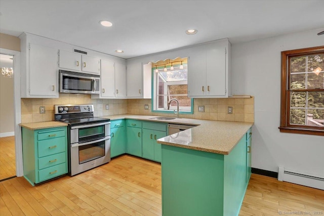 53 Montclair Dr, Manchester, CT 06042 - kitchen with stainless steel appliances, a peninsula, light wood-type flooring, white cabinetry, and recessed lighting