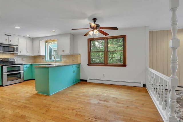 53 Montclair Dr, Manchester, CT 06042 - kitchen featuring stainless steel appliances, baseboard heating, a peninsula, ceiling fan, and backsplash