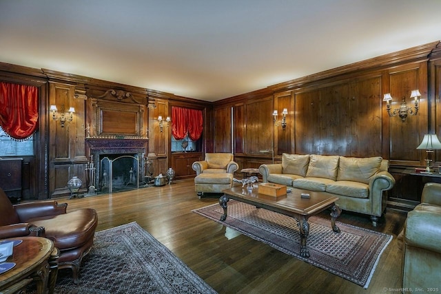 living room featuring dark wood-style floors, a fireplace, and wooden walls