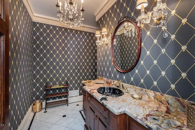 bathroom with vanity, a chandelier, marble look tiles, crown molding, and wallpapered walls