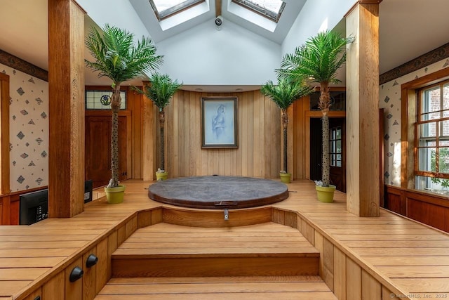 common area featuring wallpapered walls, vaulted ceiling, and a security system