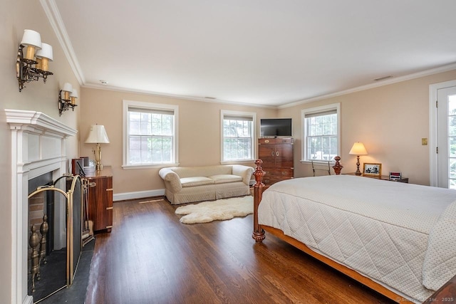 bedroom featuring dark wood finished floors, multiple windows, crown molding, and a fireplace
