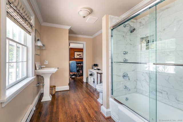 bathroom featuring wood finished floors, combined bath / shower with glass door, plenty of natural light, ornamental molding, and baseboard heating