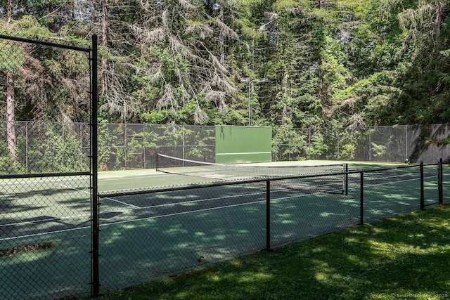 view of tennis court with a view of trees
