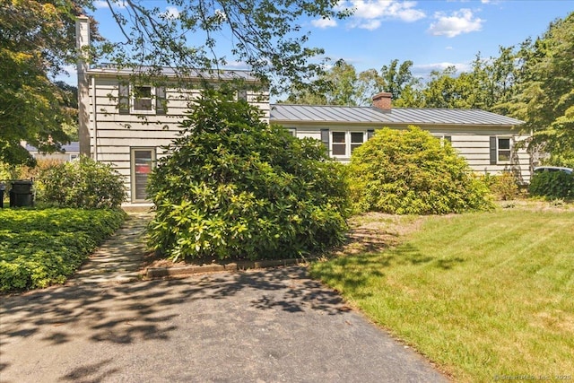 45 Canton Rd, Granby, CT 06035 - view of front of home with a standing seam roof, a chimney, a front yard, and a metal roof