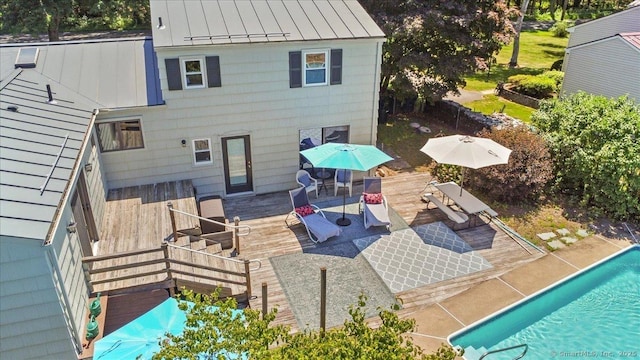 45 Canton Rd, Granby, CT 06035 - back of property featuring a standing seam roof, an outdoor pool, a metal roof, outdoor dining space, and a wooden deck