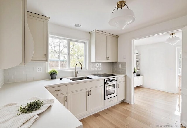 45 Canton Rd, Granby, CT 06035 - kitchen with stainless steel oven, backsplash, light wood-style flooring, light countertops, and pendant lighting