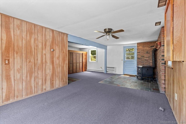 45 Canton Rd, Granby, CT 06035 - unfurnished living room with a wood stove, wooden walls, a ceiling fan, and carpet