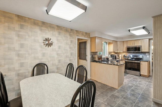 18 Banks Rd, Simsbury, CT 06070 - kitchen with stainless steel appliances, light brown cabinetry, dark countertops, backsplash, and a peninsula