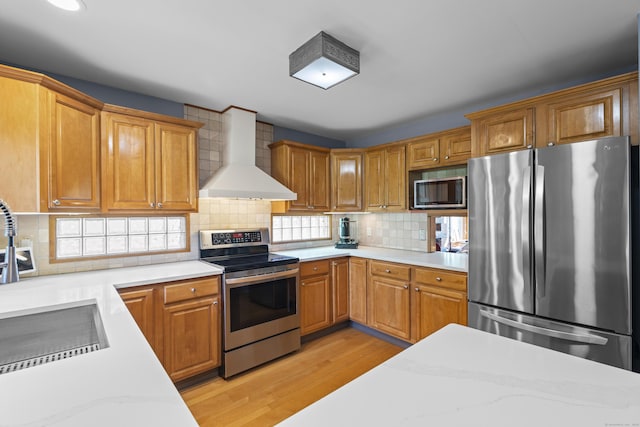 34 Joyce St, Guilford, CT 06437 - kitchen with appliances with stainless steel finishes, wall chimney range hood, light wood-style floors, decorative backsplash, and recessed lighting