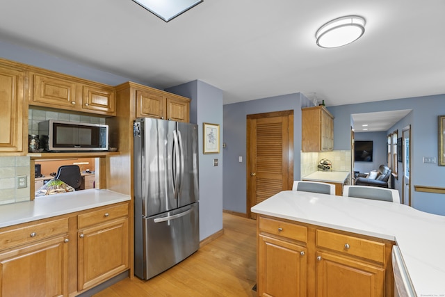 34 Joyce St, Guilford, CT 06437 - kitchen with stainless steel appliances, light countertops, light wood-type flooring, and backsplash