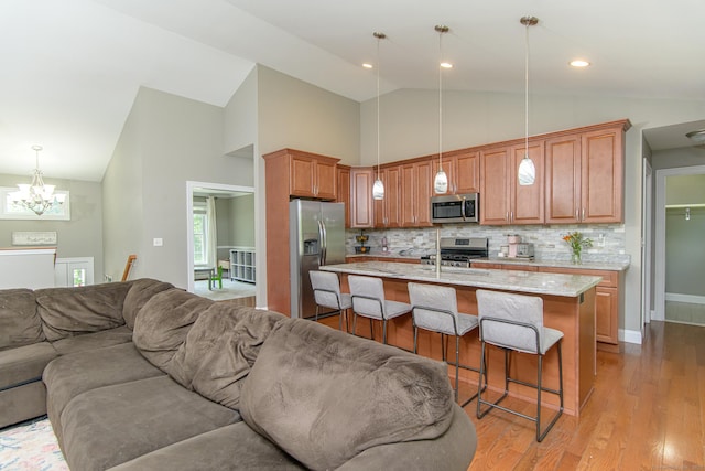 40 Airport Rd, Killingly, CT 06239 - kitchen with appliances with stainless steel finishes, open floor plan, a chandelier, a breakfast bar area, and light wood finished floors