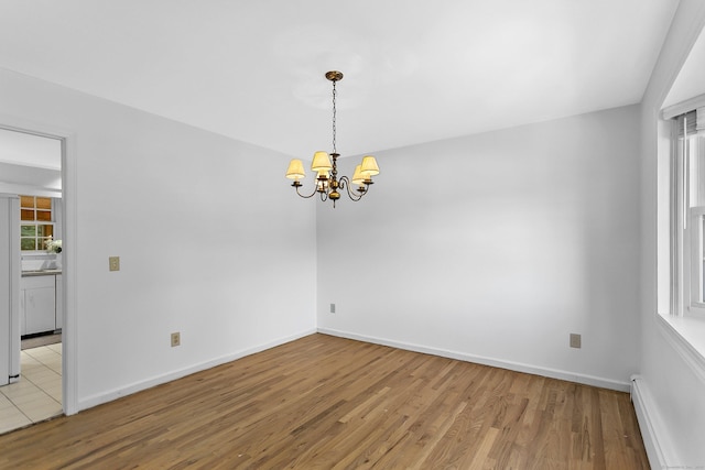 210 Carroll Rd, Fairfield, CT 06824 - unfurnished room with a baseboard radiator, wood finished floors, and a chandelier