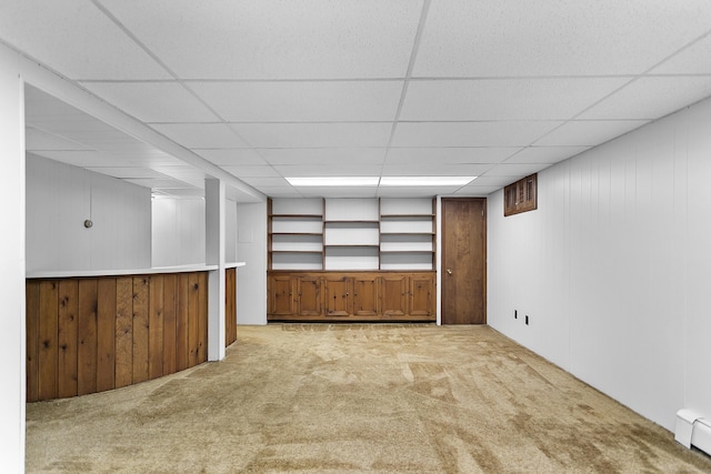 210 Carroll Rd, Fairfield, CT 06824 - finished basement with light carpet, a baseboard heating unit, a paneled ceiling, and wood walls