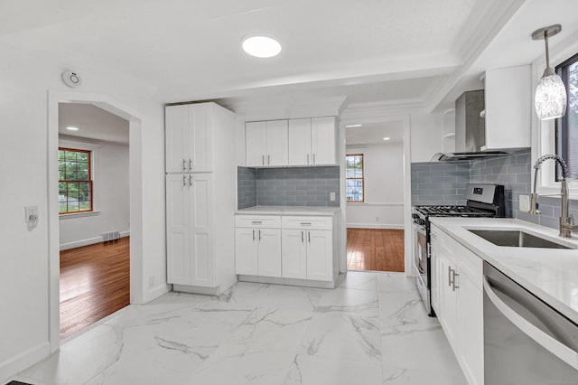 162 Sheppard St, Stratford, CT 06614 - kitchen featuring appliances with stainless steel finishes, wall chimney range hood, white cabinets, and decorative backsplash