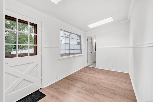 162 Sheppard St, Stratford, CT 06614 - spare room featuring a skylight, crown molding, a wainscoted wall, light wood finished floors, and healthy amount of natural light