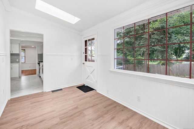 162 Sheppard St, Stratford, CT 06614 - entrance foyer featuring vaulted ceiling, a skylight, wainscoting, crown molding, and light wood-style flooring