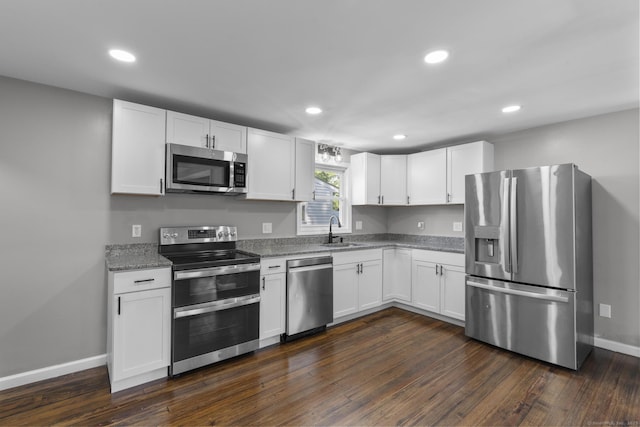 36 Greenfield St, Windsor, CT 06095 - kitchen featuring appliances with stainless steel finishes, white cabinets, recessed lighting, light stone countertops, and dark wood finished floors