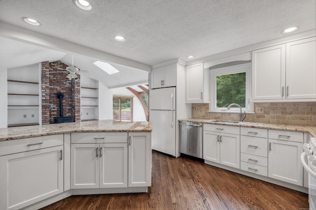 70 Brighton Rd, Hebron, CT 06248 - kitchen featuring dishwasher, freestanding refrigerator, a skylight, a wood stove, and dark wood-style floors