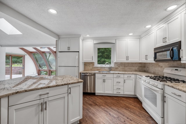 70 Brighton Rd, Hebron, CT 06248 - kitchen with white appliances, a skylight, a textured ceiling, white cabinets, and recessed lighting