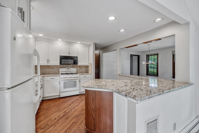 70 Brighton Rd, Hebron, CT 06248 - kitchen with white appliances, light wood-style floors, recessed lighting, white cabinets, and backsplash