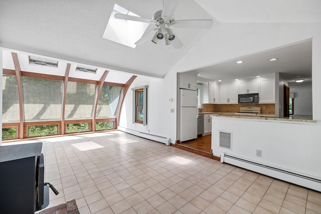 70 Brighton Rd, Hebron, CT 06248 - kitchen with black microwave, freestanding refrigerator, a baseboard heating unit, range, and ceiling fan