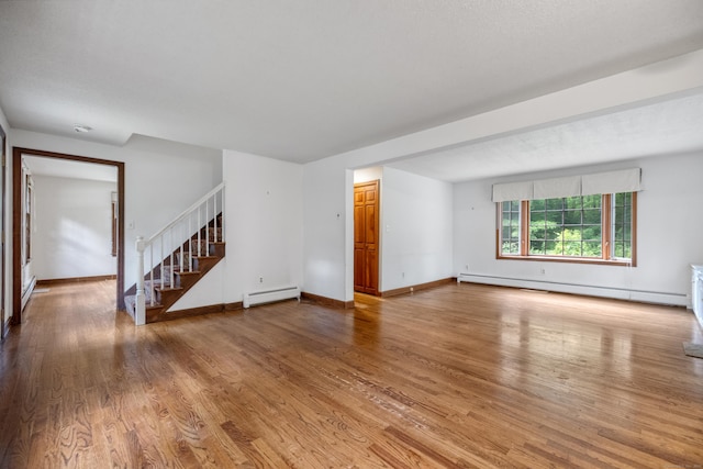 70 Brighton Rd, Hebron, CT 06248 - unfurnished living room with a baseboard heating unit, stairs, baseboard heating, and wood finished floors