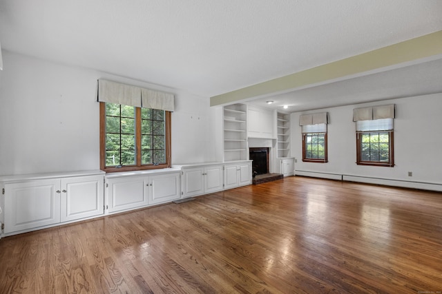 70 Brighton Rd, Hebron, CT 06248 - unfurnished living room with baseboard heating, light wood-style floors, and plenty of natural light
