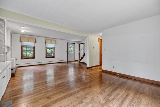 70 Brighton Rd, Hebron, CT 06248 - unfurnished living room with a baseboard radiator, stairway, and light wood-style floors