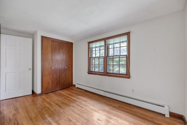 70 Brighton Rd, Hebron, CT 06248 - unfurnished bedroom with a baseboard radiator, light wood-style flooring, and a closet