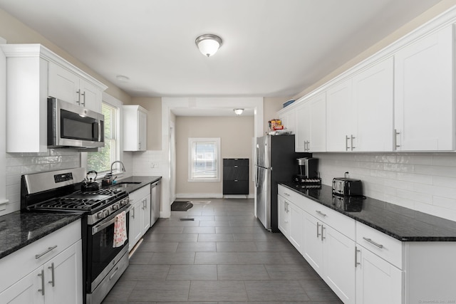 163 Willetts Ave, New London, CT 06320 - kitchen featuring appliances with stainless steel finishes, white cabinets, decorative backsplash, and dark stone counters