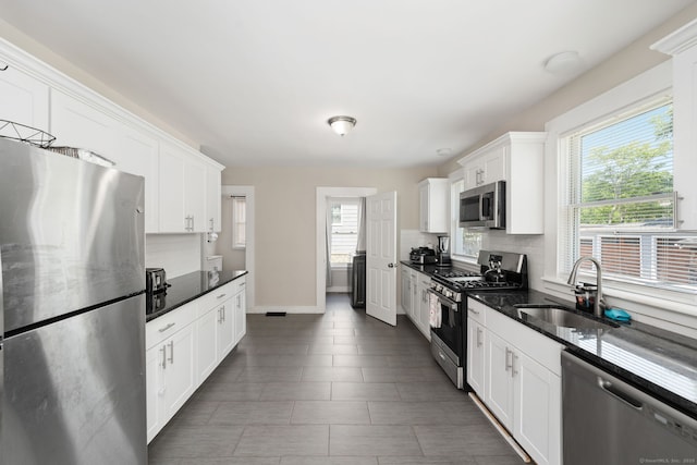 163 Willetts Ave, New London, CT 06320 - kitchen featuring appliances with stainless steel finishes, white cabinets, tasteful backsplash, and dark stone countertops
