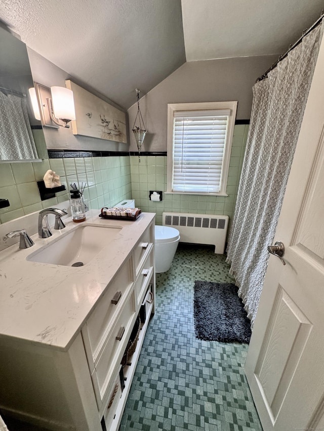 34 Federal St, West Hartford, CT 06110 - full bath featuring radiator, tile walls, vanity, vaulted ceiling, and tile patterned floors