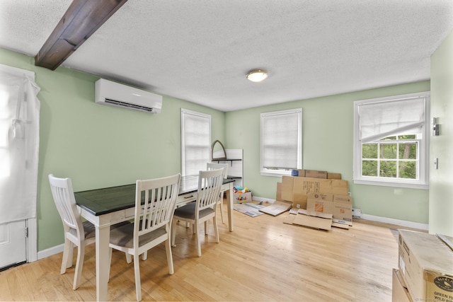 64 Iron St, Ledyard, CT 06339 - dining room featuring a wall unit AC, a textured ceiling, wood finished floors, and plenty of natural light