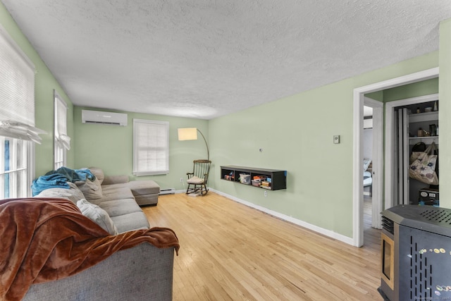 64 Iron St, Ledyard, CT 06339 - living area with a wall unit AC, a textured ceiling, wood finished floors, and baseboard heating