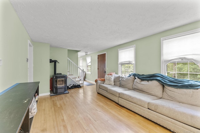 64 Iron St, Ledyard, CT 06339 - living room featuring light wood-type flooring, a textured ceiling, stairs, and a wood stove