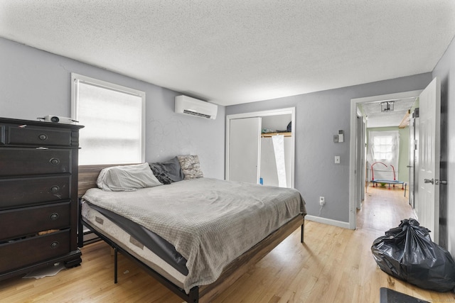64 Iron St, Ledyard, CT 06339 - bedroom with a wall mounted air conditioner, a textured ceiling, light wood-style flooring, and a closet