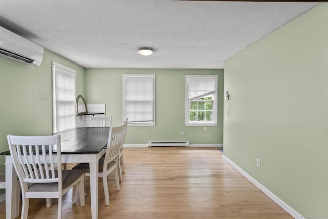 64 Iron St, Ledyard, CT 06339 - dining room with an AC wall unit, baseboard heating, light wood-type flooring, and a textured ceiling