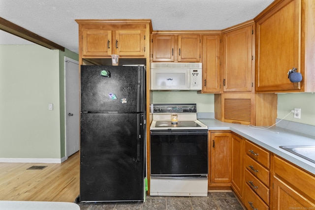 64 Iron St, Ledyard, CT 06339 - kitchen featuring freestanding refrigerator, white microwave, range with electric cooktop, a textured ceiling, and light countertops