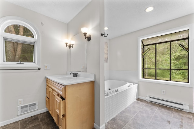 64 Iron St, Ledyard, CT 06339 - bathroom with baseboard heating, vanity, a tub with jets, and a textured ceiling