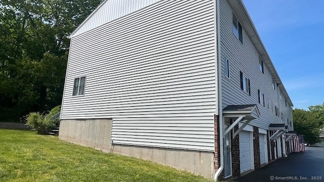 view of home's exterior featuring a lawn and an attached garage